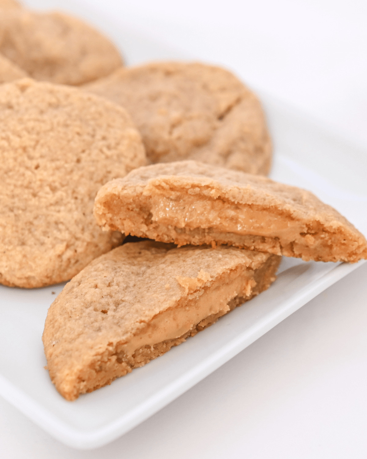 Peanut butter stuffed cookies on a white plate.