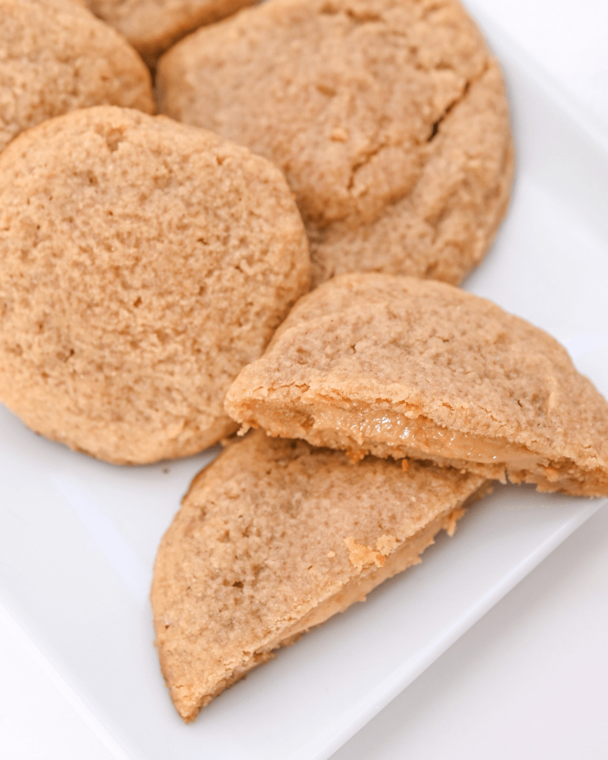 Peanut butter stuffed cookies on a white plate.