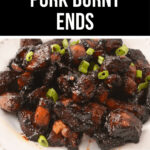 Serving of pork burnt ends presented on a white plate.