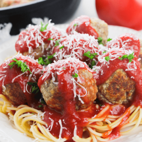 Ricotta meatballs served on a plate with spaghetti and sauce.