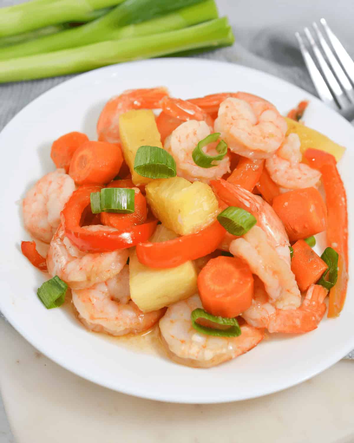 A plate with sheet pan shrimp teriyaki and pineapple.