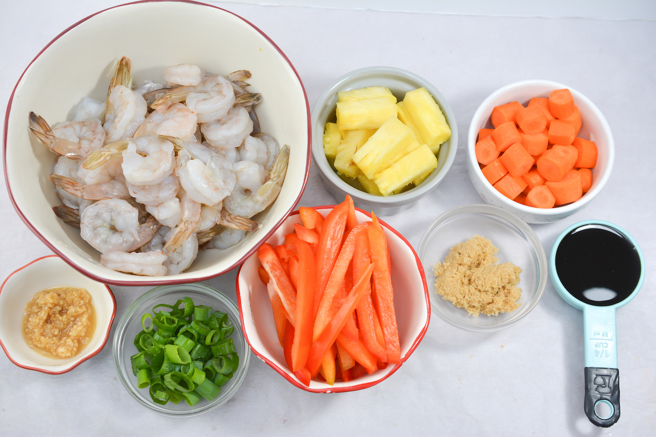 A bowl with shrimp, carrots and other ingredients.