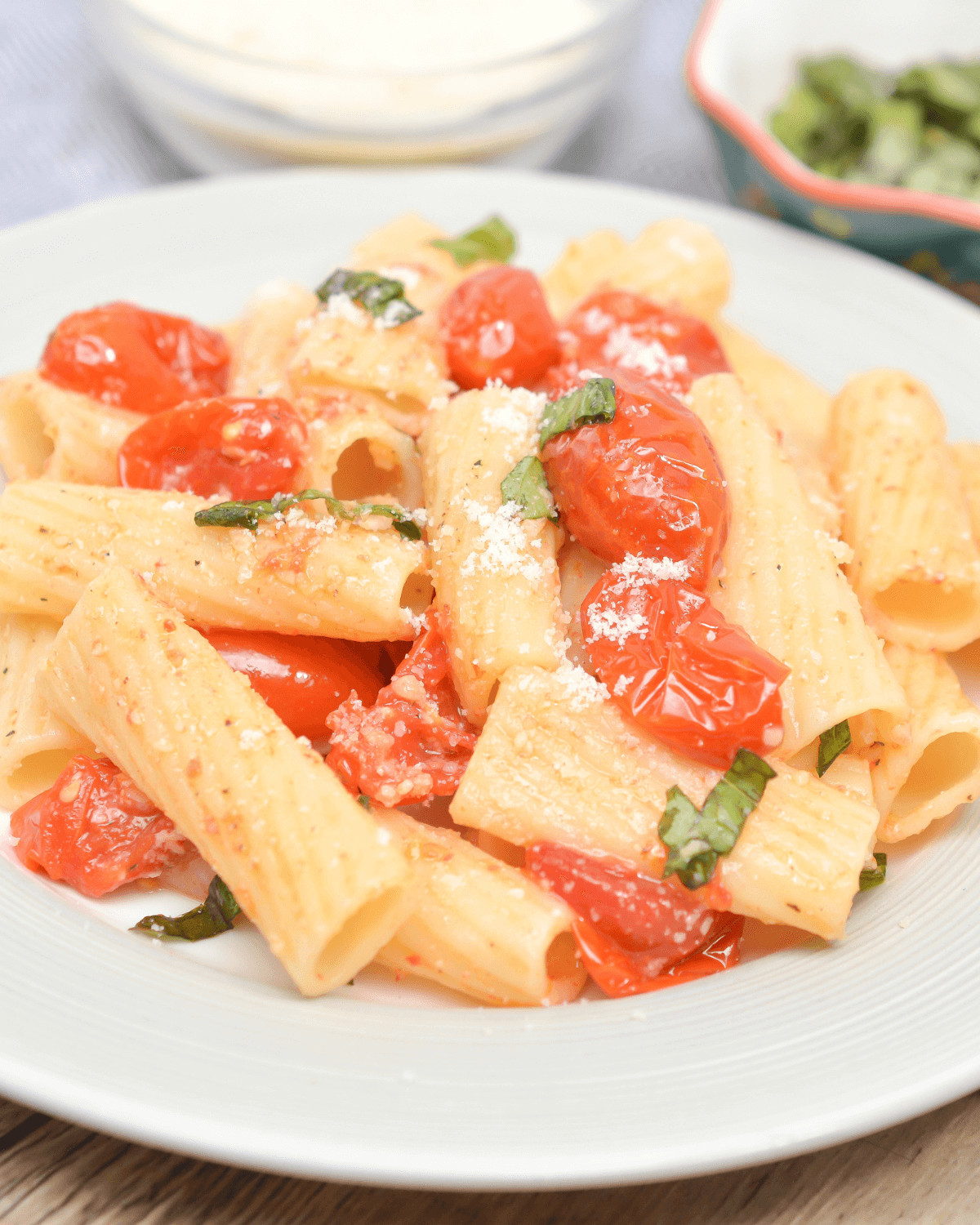 Indulge in a flavorful plate of slow roasted tomato basil pasta topped with parmesan cheese.