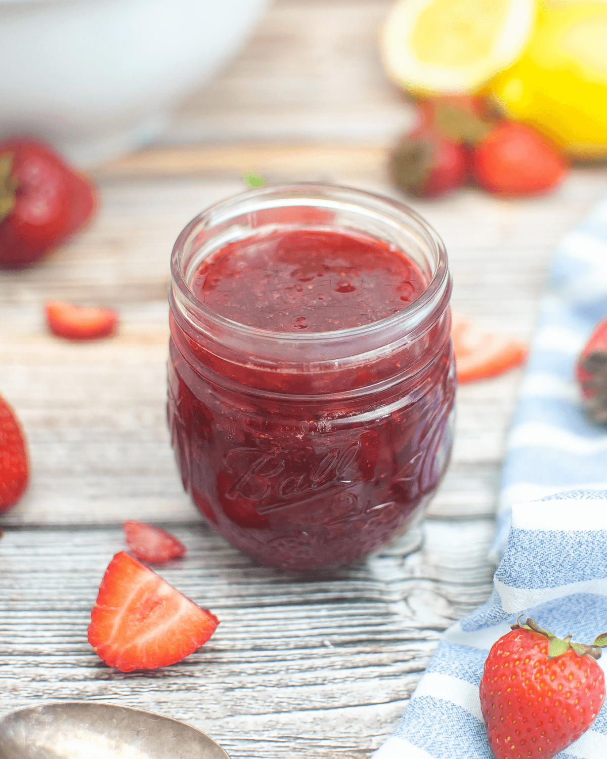 Strawberry jam without pectin in a jar on a wooden table.
