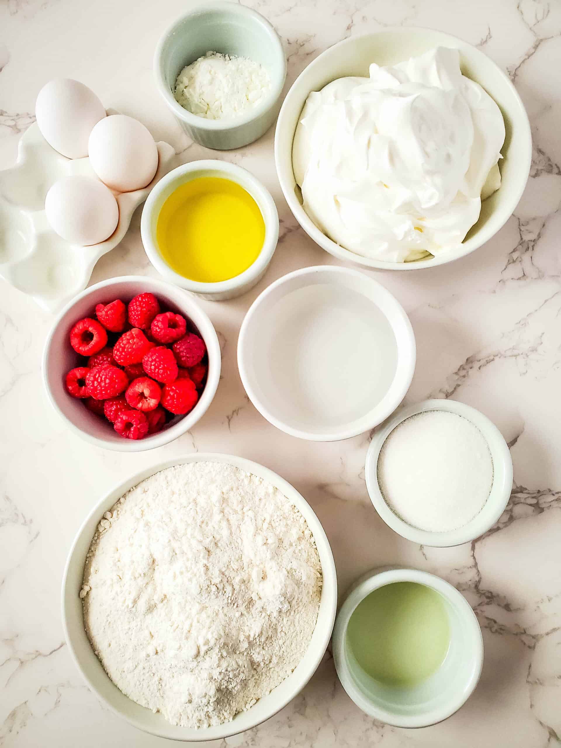 A bowl of ingredients for a vanilla raspberry cake with whipped cream.