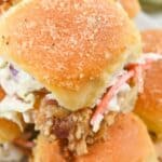 Close-up of BBQ Chicken Sliders on soft buns filled with fried chicken and coleslaw, arranged on a white plate.