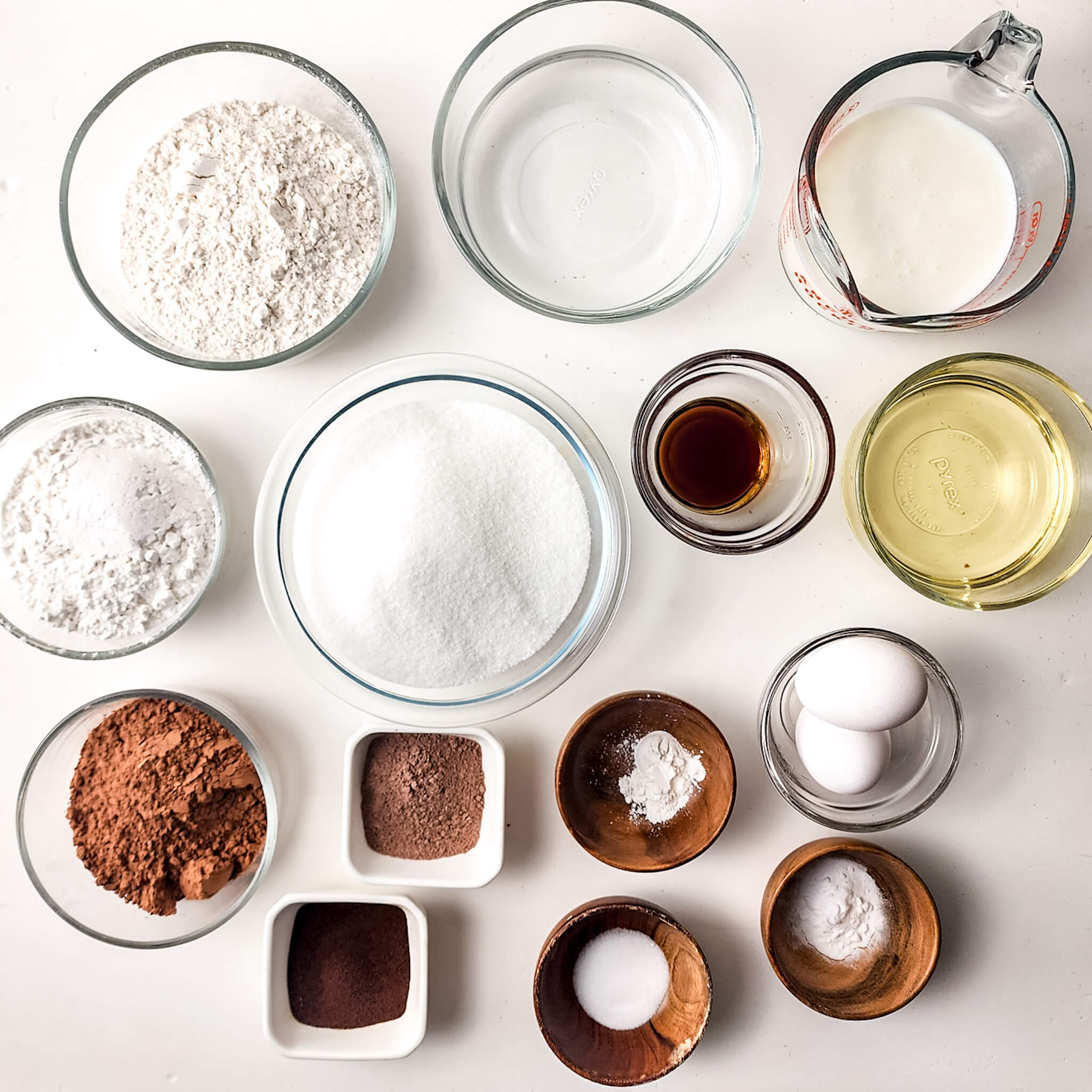 Assorted baking ingredients for the dessert arranged neatly on a white surface.