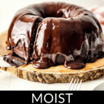 Chocolate chip bundt cake with glossy glaze on a wooden serving plate.
