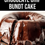 Chocolate chip Bundt cake topped with glossy chocolate glaze on a wooden stand.