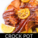 Glazed crock pot spiral ham with citrus garnish.