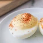 A close-up topped with paprika, served on a white plate this tempting treat.
