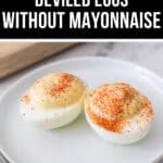 Two Deviled Eggs without Mayonnaise, sprinkled with paprika and served on a white plate for a lighter twist on the classic appetizer.