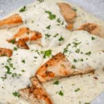 Grilled chicken breasts topped in skillet.