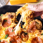 A hand stretching away from the rest, ready for a pizza dip.