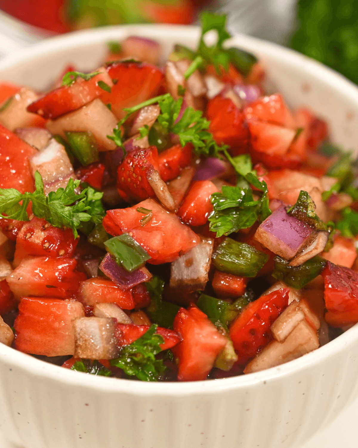 A white bowl of strawberry salsa.