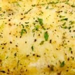 Close-up of a seasoned omelet garnished with herbs, paired alongside vibrant cherry and yellow tomatoes—perfect as a fresh side to baked haddock.
