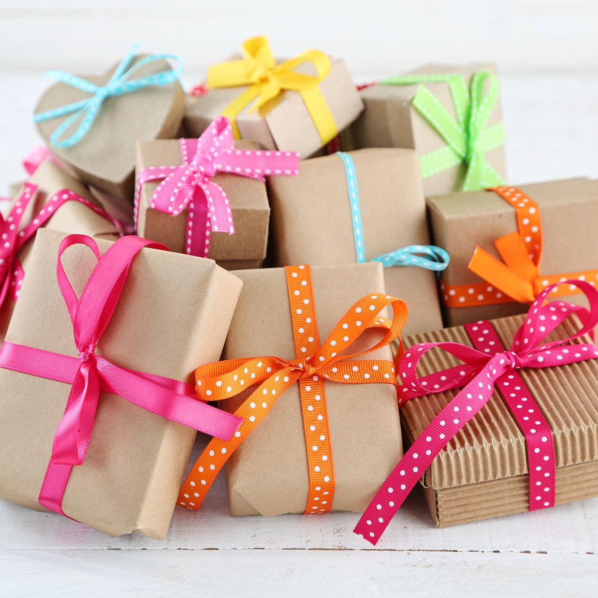 A pile of gift boxes with colorful ribbons on a white recipe index.