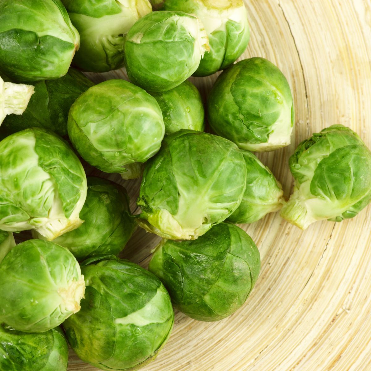 A close-up image of fresh brussels sprouts displayed on a wooden surface for a recipe index.
