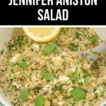 A bowl of quinoa salad with chickpeas, feta cheese, and fresh mint, garnished with a lemon wedge, featuring text overlay "Jennifer Aniston Salad.