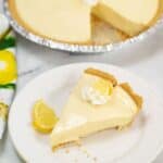 A slice served on a white plate; the rest of the pie is in the background with one slice missing.