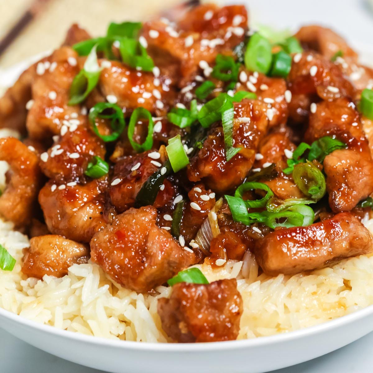 A close-up from our recipe index: teriyaki chicken over rice, garnished with sesame seeds and chopped green onions.