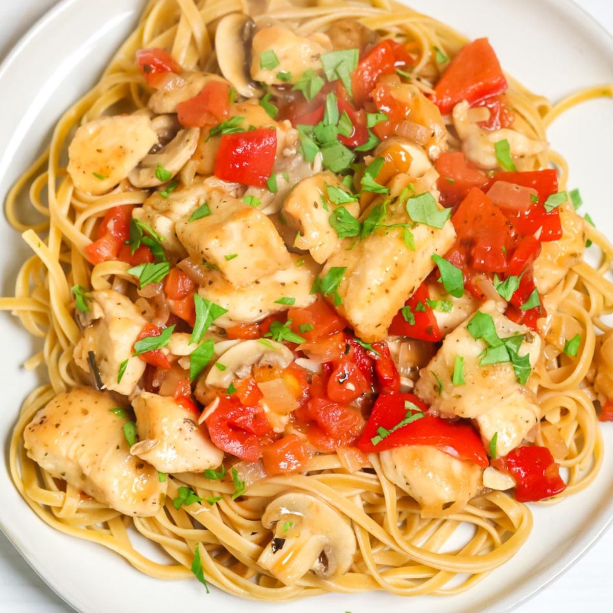 A recipe index entry for a plate of spaghetti topped with chicken, mushrooms, tomatoes, and garnished with chopped parsley.