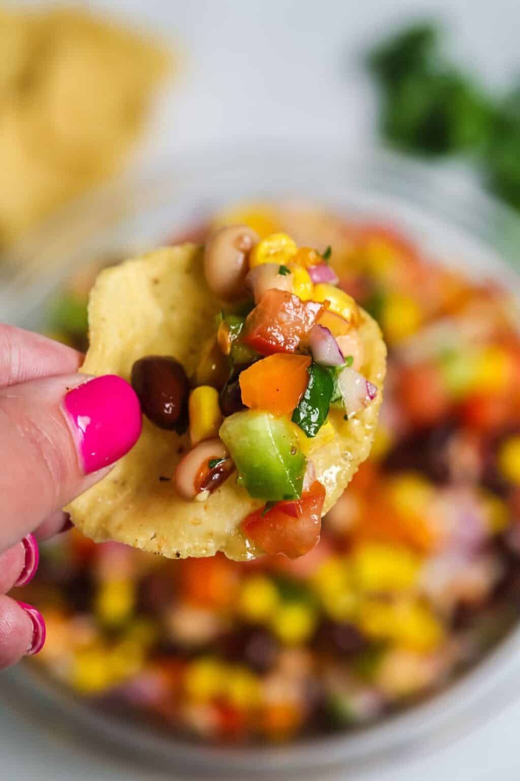 A hand holding a chip with the easy redneck caviar.