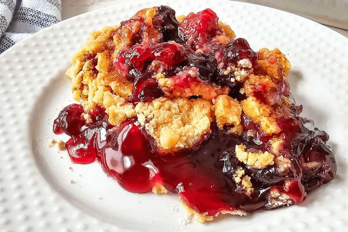 Blueberry cherry dump cake on a white plate. 