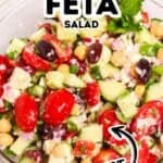A bowl of Chickpea Feta Salad with tomatoes, cucumbers, olives, red onions, and herbs. Text reads "Chickpea Feta Salad" and "The Best.