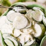 A bowl of creamy, dill-flavored dressing, with a spoon resting in the bowl.