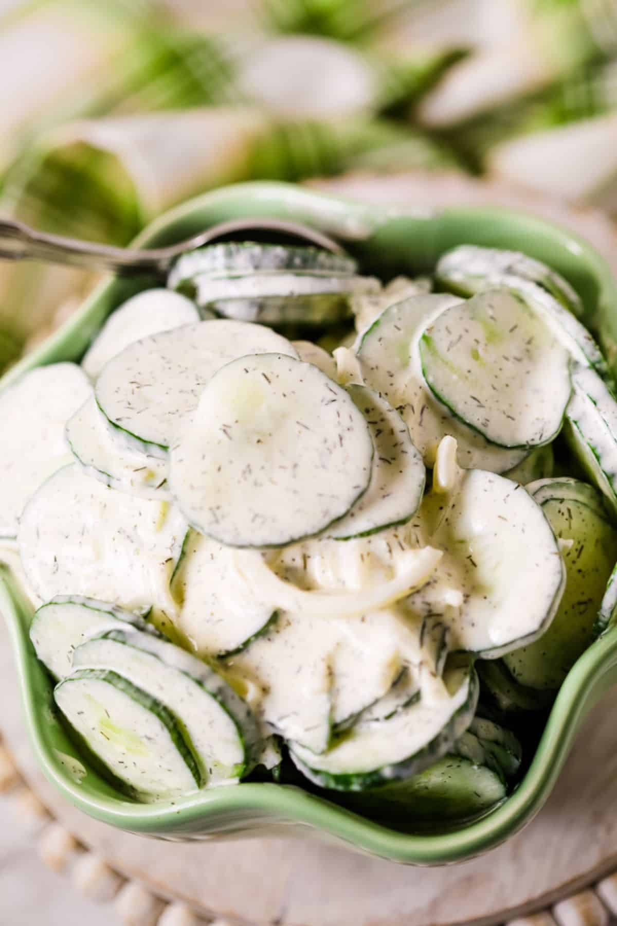 A bowl of creamy, dill-flavored dressing, with a spoon resting in the bowl.
