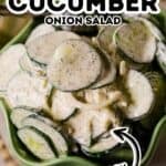 A green bowl filled with sliced cucumbers and onions coated in a creamy dressing, labeled "Cucumber Onion Salad" and marked as "Easy.