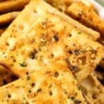 A bowl filled with seasoned saltine crackers, topped with visible herbs and spices—a perfect Spicy Crackers Recipe for snack lovers.