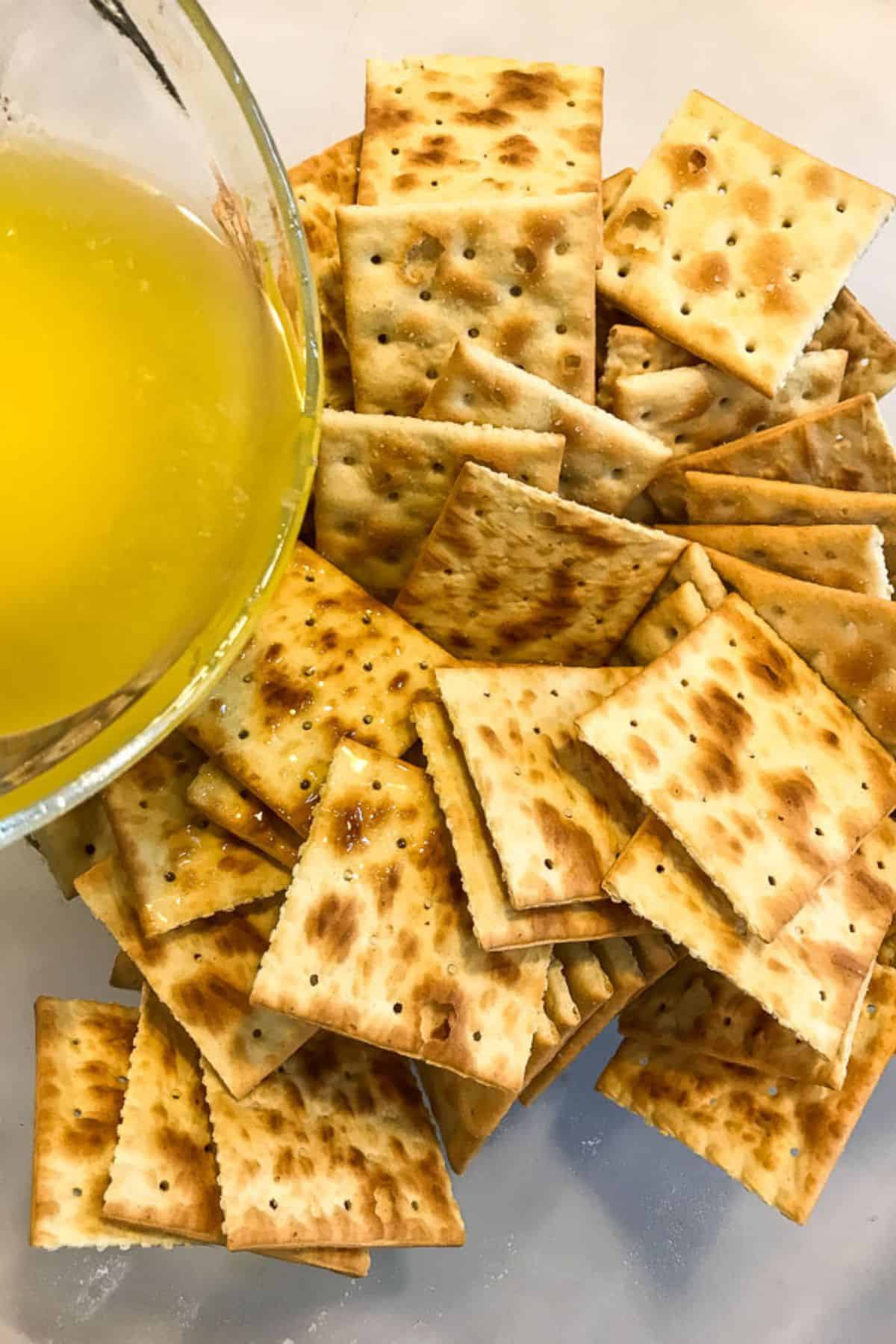 A pile of squares on a plate next to a glass bowl containing dip.