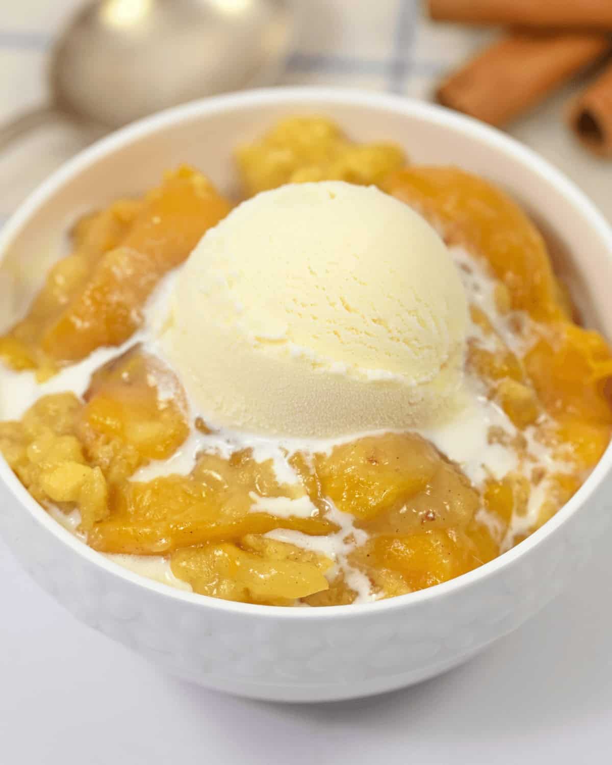 a white bowl filled with the dessert and a  scoop of vanilla ice cream.