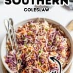 A bowl of creamy Southern Coleslaw with shredded cabbage and carrots, garnished with green onions, and two forks placed inside the bowl. This classic side dish brings authentic Southern flavor to any meal.