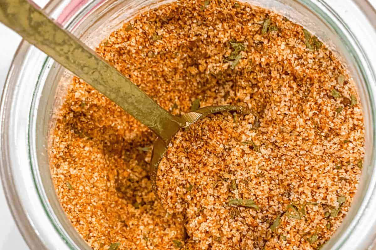 Close-up of best burger seasoning with a spoon going into it. 