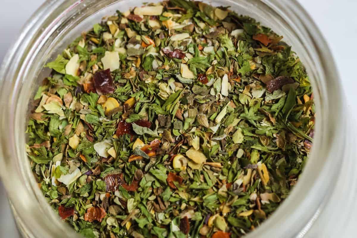 Mulit-colored close-up of spaghetti seasoning in a glass jar.