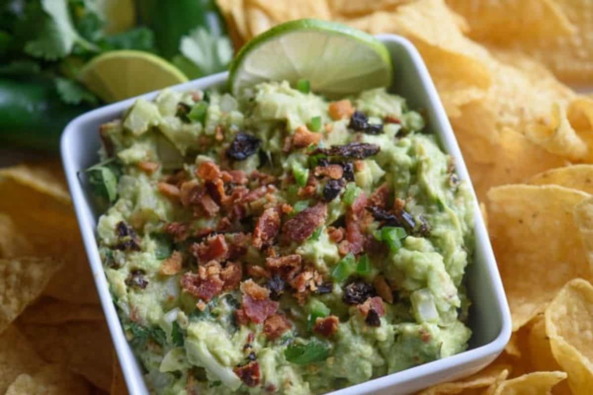 White bowl of camping guacamole with chips. 