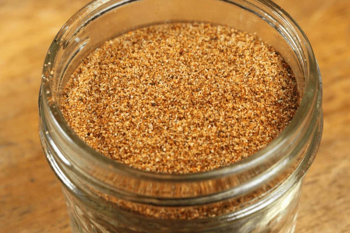 Orange colored low sodium taco seasoning in glass jar. 