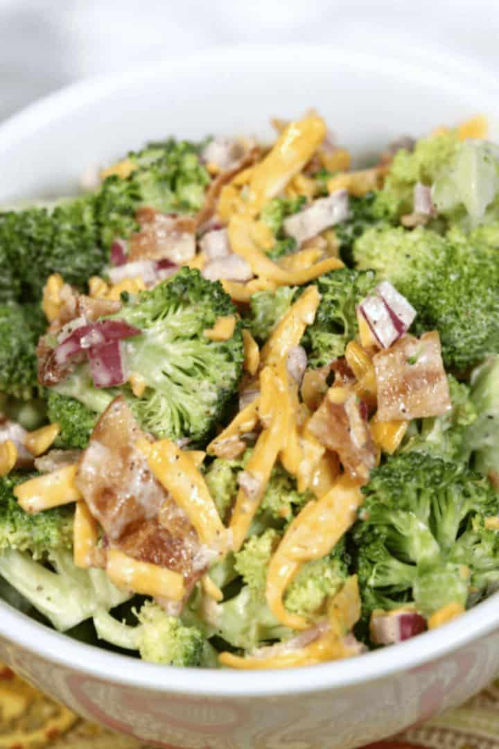 A close up on a bowl of creamy amish broccoli salad.