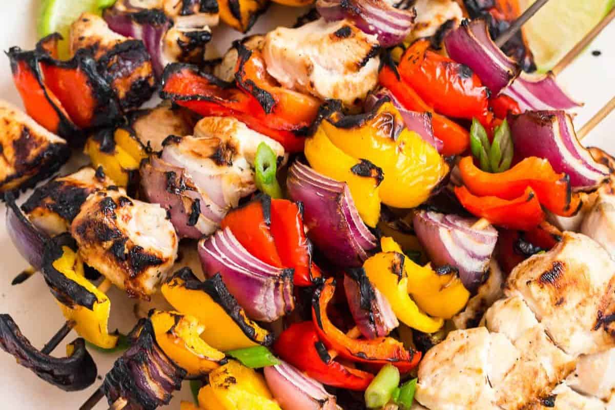 Grilled kabob skewers with chunks of chicken, red onion, red and yellow bell peppers, and green peppers, all with delicious char marks—a tasty addition to your collection of kabob recipes.