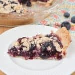 A slice on a white plate and a few berries in the background.