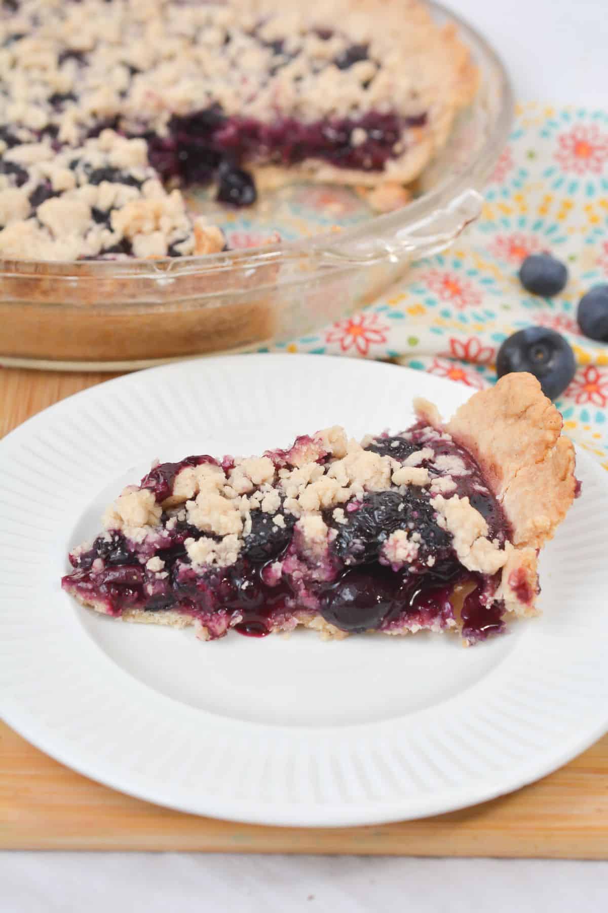 A slice on a white plate and a few berries in the background.