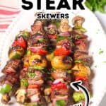 Platter with grilled steak skewers, featuring tender steak kabobs, mushrooms, potatoes, bell peppers, and onions. Fresh herbs are sprinkled on top, with “Grilled Steak Skewers Juicy” text overlays.