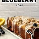 A rectangular Lemon Blueberry Loaf with icing and streusel sits on a white plate, garnished with blueberries and a lemon half nearby. Text reads "Lemon Blueberry Loaf, Fresh.