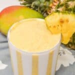 A glass of the drink with the fruit in the background.