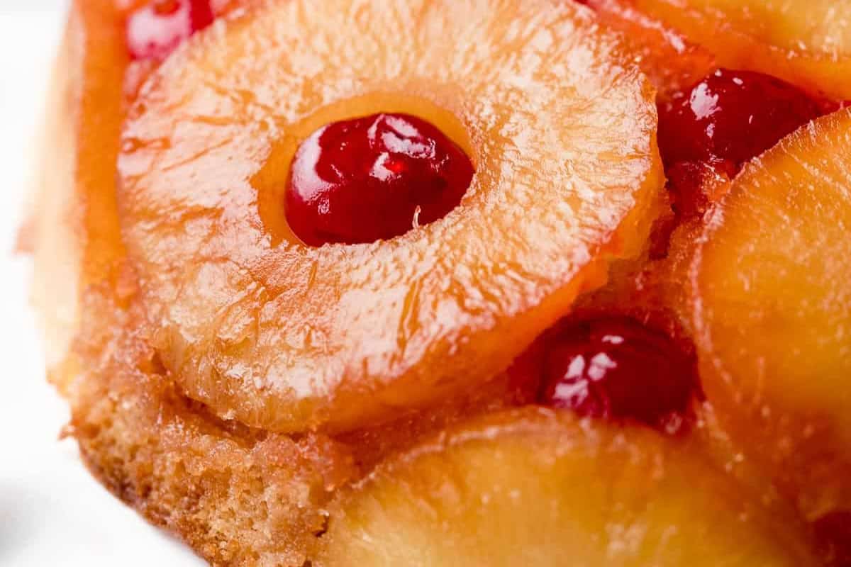 Close-up of a pineapple upside-down cake topped with pineapple rings and maraschino cherries—a must try for fans of mouthwatering Pineapple recipes.