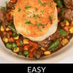 A bowl of beef pot pie topped with a biscuit. The dish features beef, green beans, corn, and carrots in a savory sauce. Text at the bottom reads "Easy Skillet Beef Pot Pie.