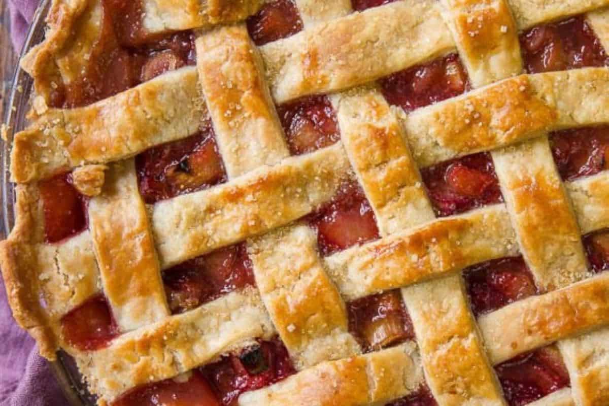 Close-up of a strawberry rhubarb pie with a criss-cross pattern on top.